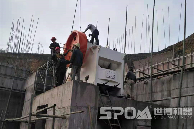 石場大型顎式破碎機安裝現(xiàn)場，需要四五人合力